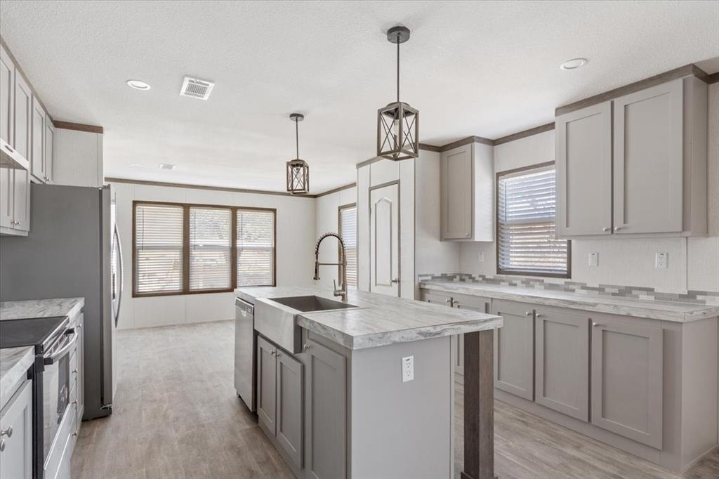 201 North Carpenter Street Mart, TX 76664 - Photo 3 of 30 a kitchen with stainless steel appliances granite countertop a sink stove and refrigerator