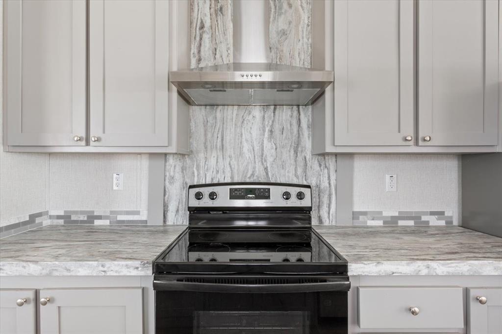 201 North Carpenter Street Mart, TX 76664 - Photo 5 of 30 a kitchen with granite countertop a stove sink and cabinets