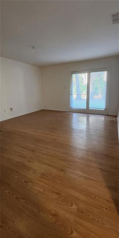 232 Afton Square, Unit 108 Altamonte Springs, FL 32714 - Photo 14 of 26 a view of empty room with window and wooden floor