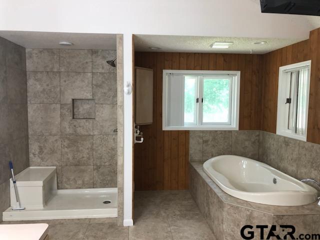 13745 Meadow Lane Flint, TX 75762 - Photo 17 of 38 a bathroom with a bathtub and a shower