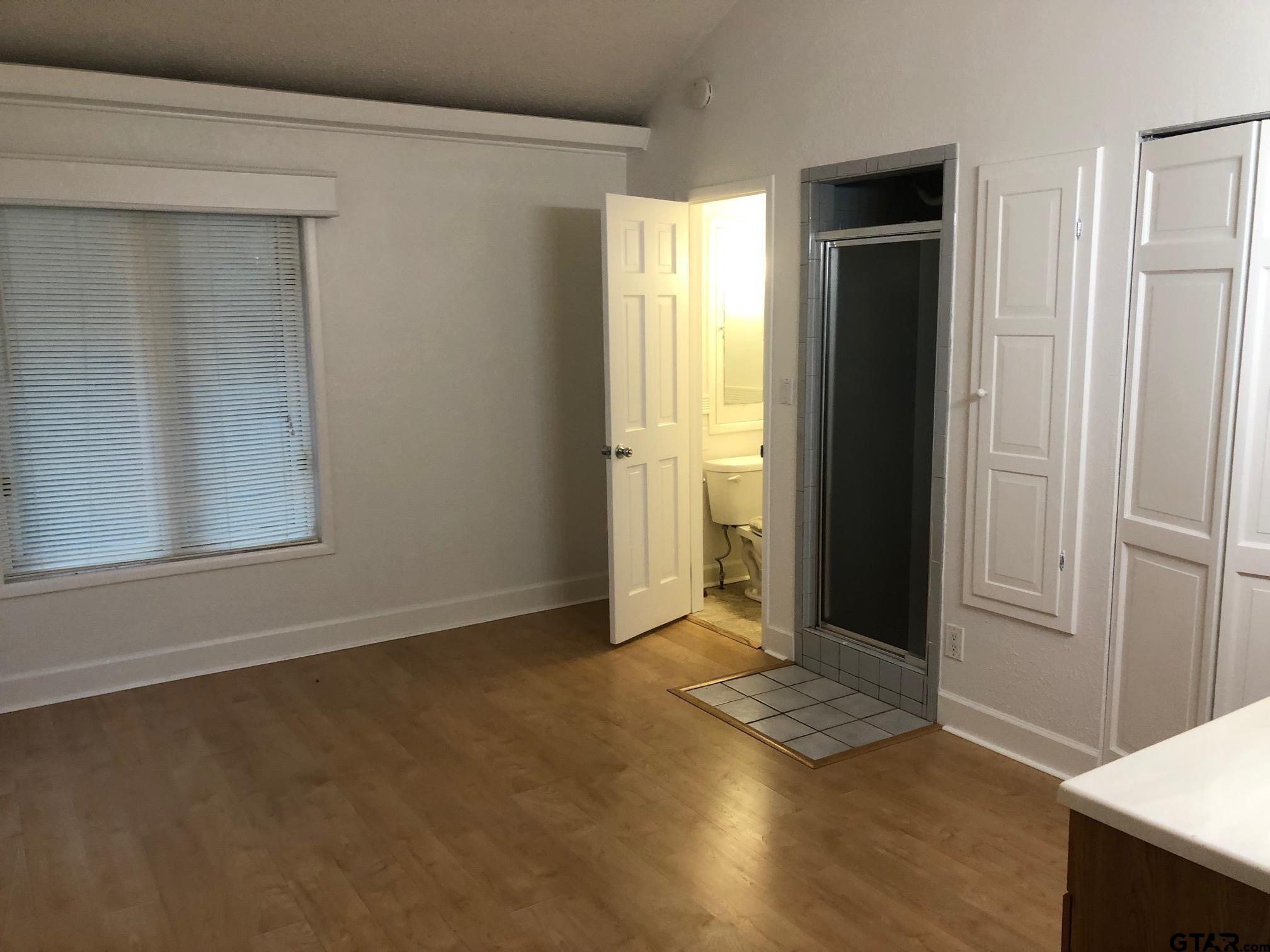 13745 Meadow Lane Flint, TX 75762 - Photo 34 of 38 an empty room with wooden floor and windows