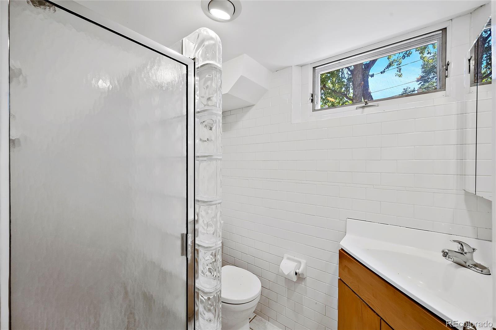 874 9th Street Boulder, CO 80302 - Photo 18 of 23 a bathroom with a shower sink vanity mirror and toilet