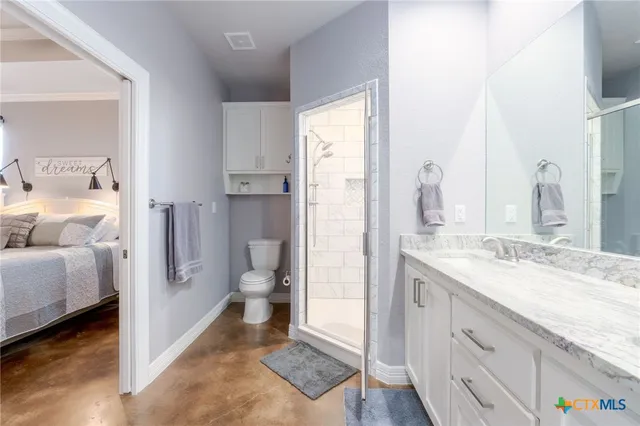 a spacious bathroom with a granite countertop sink and a mirror