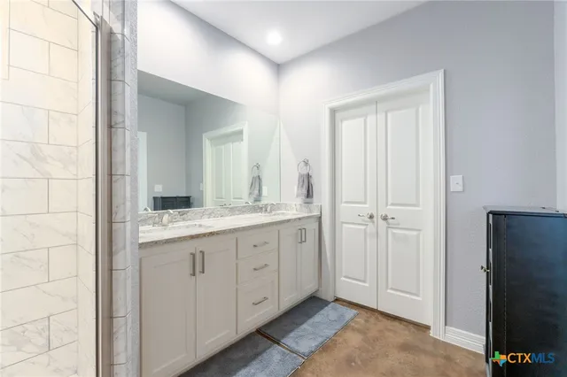 a bathroom with a granite countertop sink and a mirror
