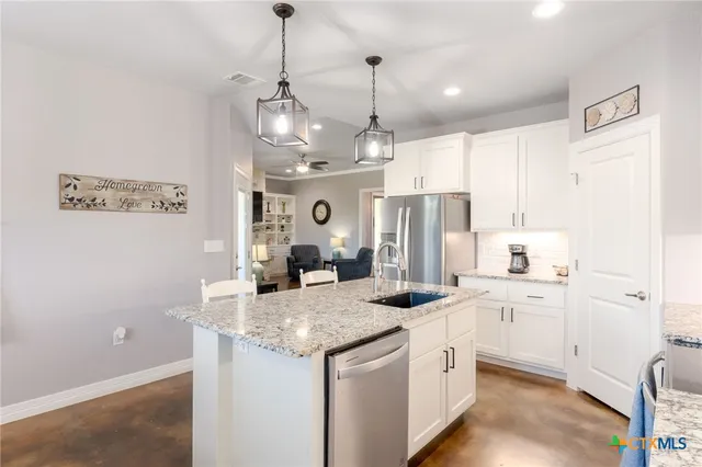a kitchen with stainless steel appliances granite countertop a sink stove and refrigerator