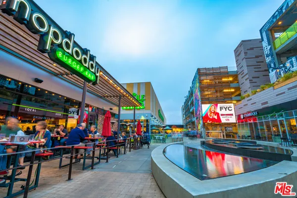 a group of people standing around a fruit stand