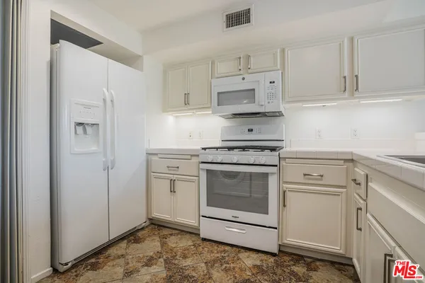 a kitchen with appliances a sink and cabinets