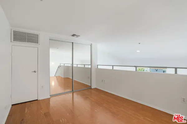 a view of empty room with wooden floor