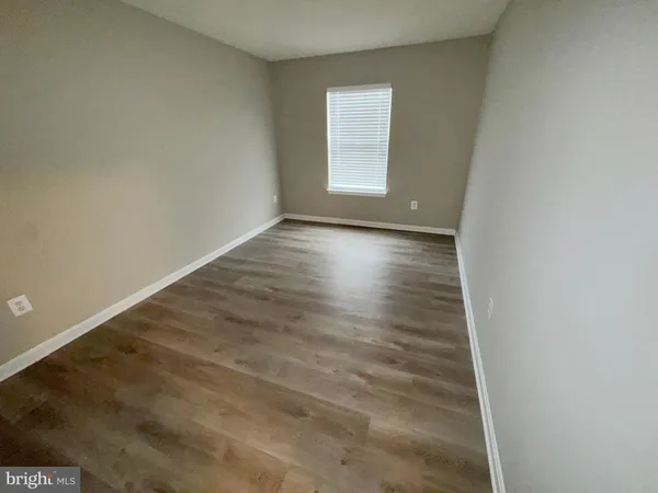 a view of a hallway with toilet and wooden floor
