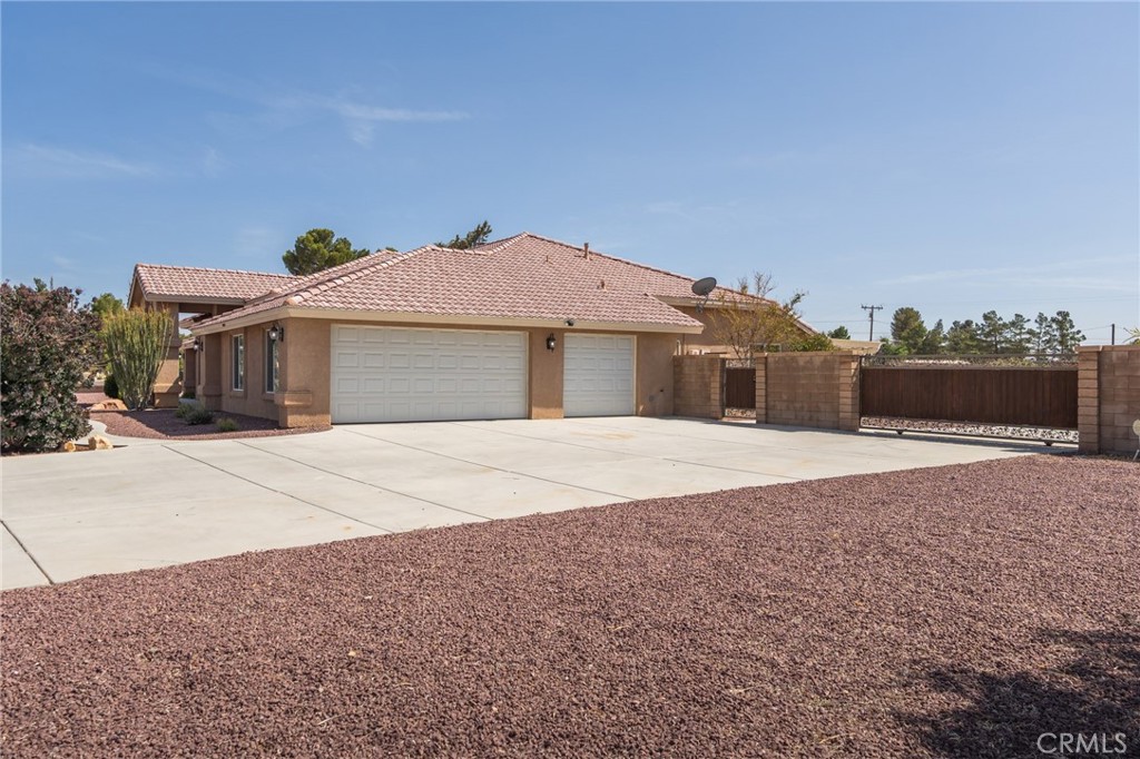 19501 Kinai Road Apple Valley, CA 92307 - Photo 6 of 49 a front view of a house with a yard and a garage