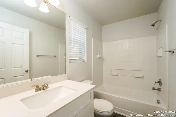 a bathroom with a bathtub shower sink vanity and toilet