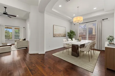 a kitchen with stainless steel appliances granite countertop a table chairs sink and cabinets