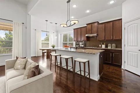 a kitchen with kitchen island granite countertop a sink appliances and cabinets