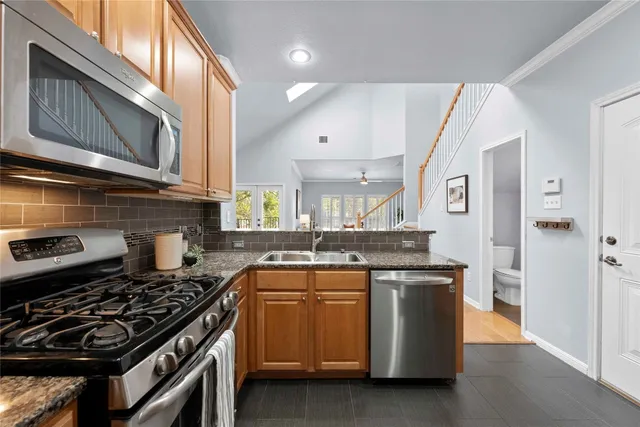 a kitchen with stainless steel appliances granite countertop a stove and a sink