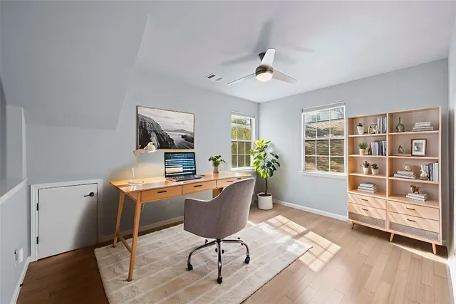 a view of a workspace with furniture and a window