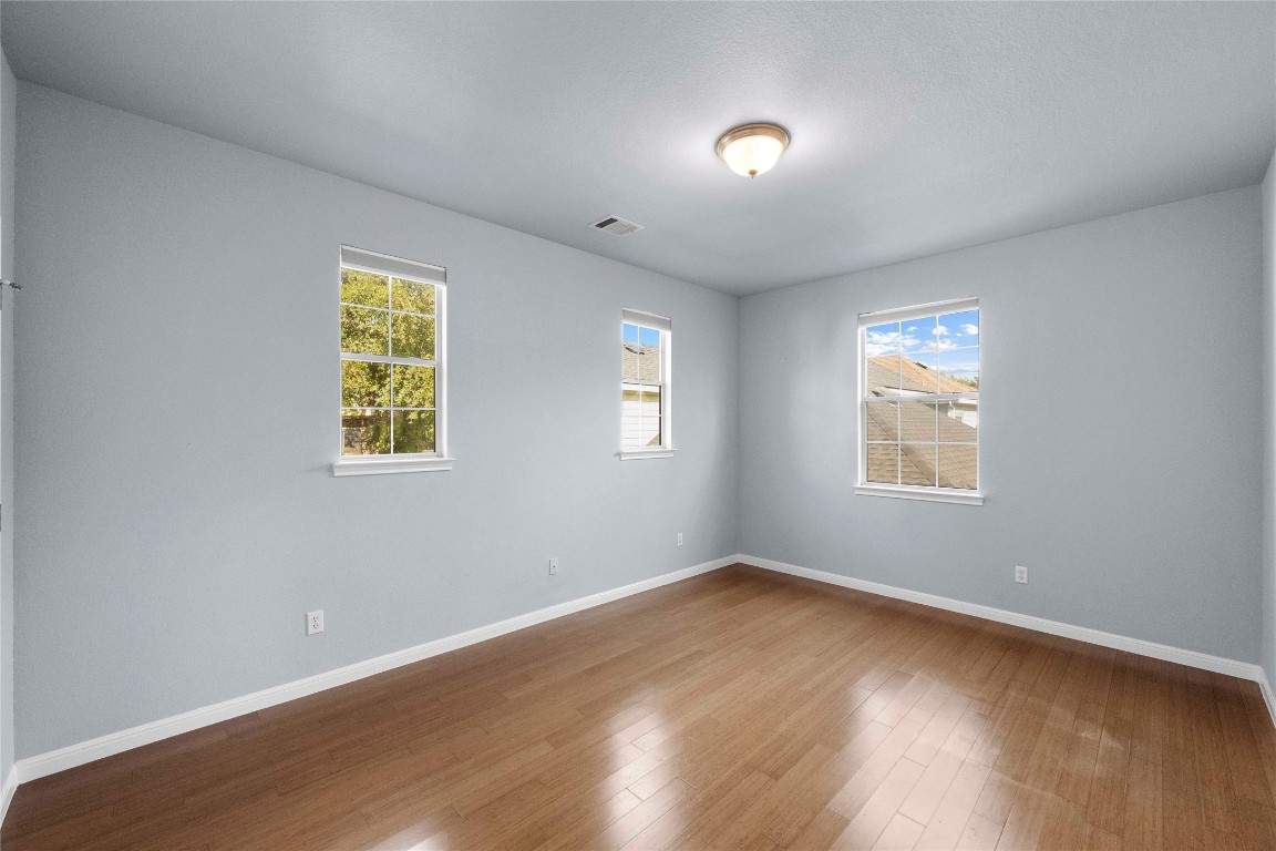 6704 Menchaca Road, Unit 29 Austin, TX 78745 - Photo 23 of 34 a view of an empty room with a window and wooden floor