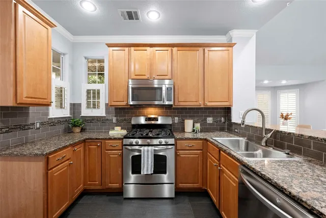 a kitchen with stainless steel appliances granite countertop a stove sink and cabinets