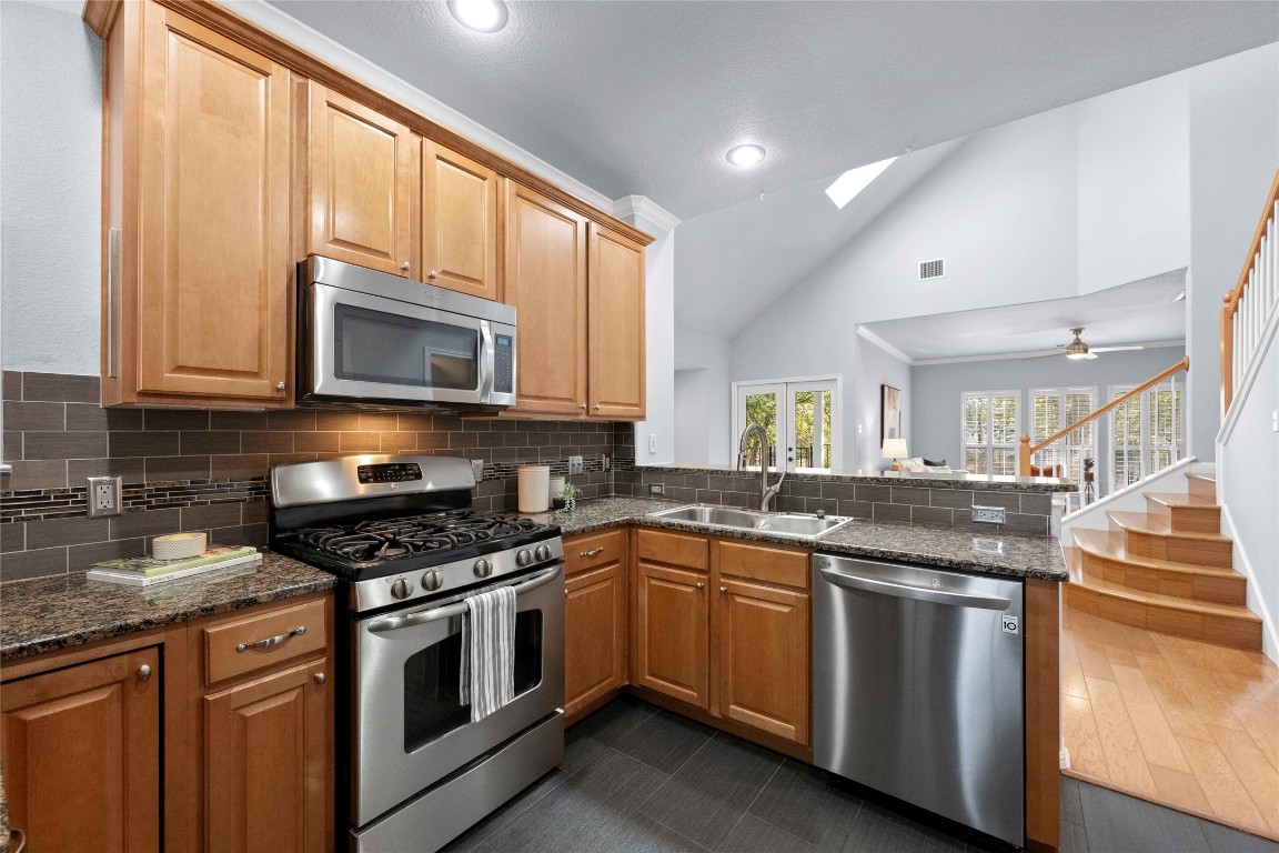 6704 Menchaca Road, Unit 29 Austin, TX 78745 - Photo 10 of 34 a kitchen with granite countertop stainless steel appliances a sink stove and microwave