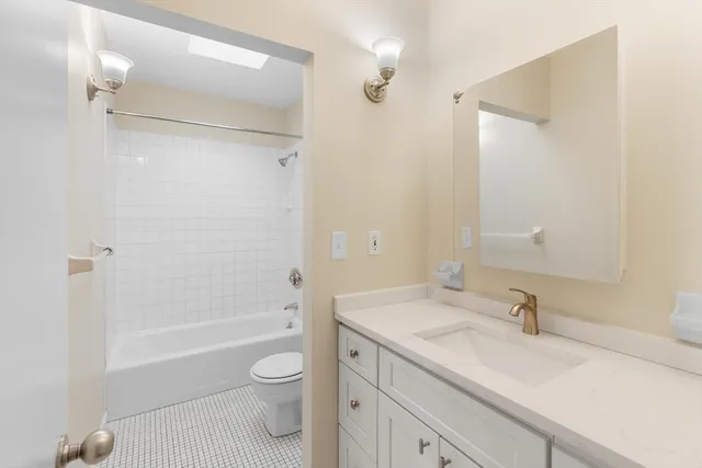 a bathroom with a granite countertop sink a toilet and shower