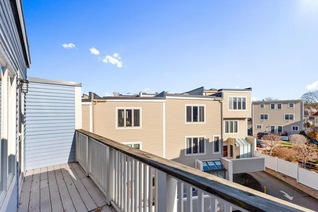 a view of a balcony with wooden floor and fence and a floor to ceiling window