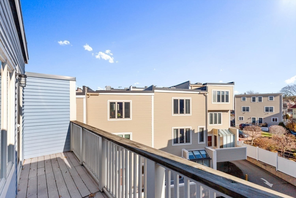 676 Huron Avenue, Unit 43 Cambridge, MA 02138 - Photo 17 of 20 a view of a balcony with wooden floor and fence and a floor to ceiling window