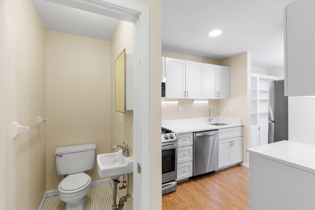 676 Huron Avenue, Unit 43 Cambridge, MA 02138 - Photo 7 of 20 a kitchen with a stove a sink and a refrigerator