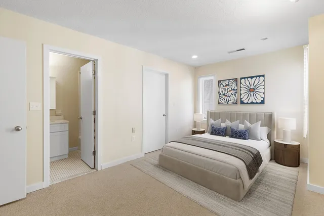 a bedroom with a large bed and a painting