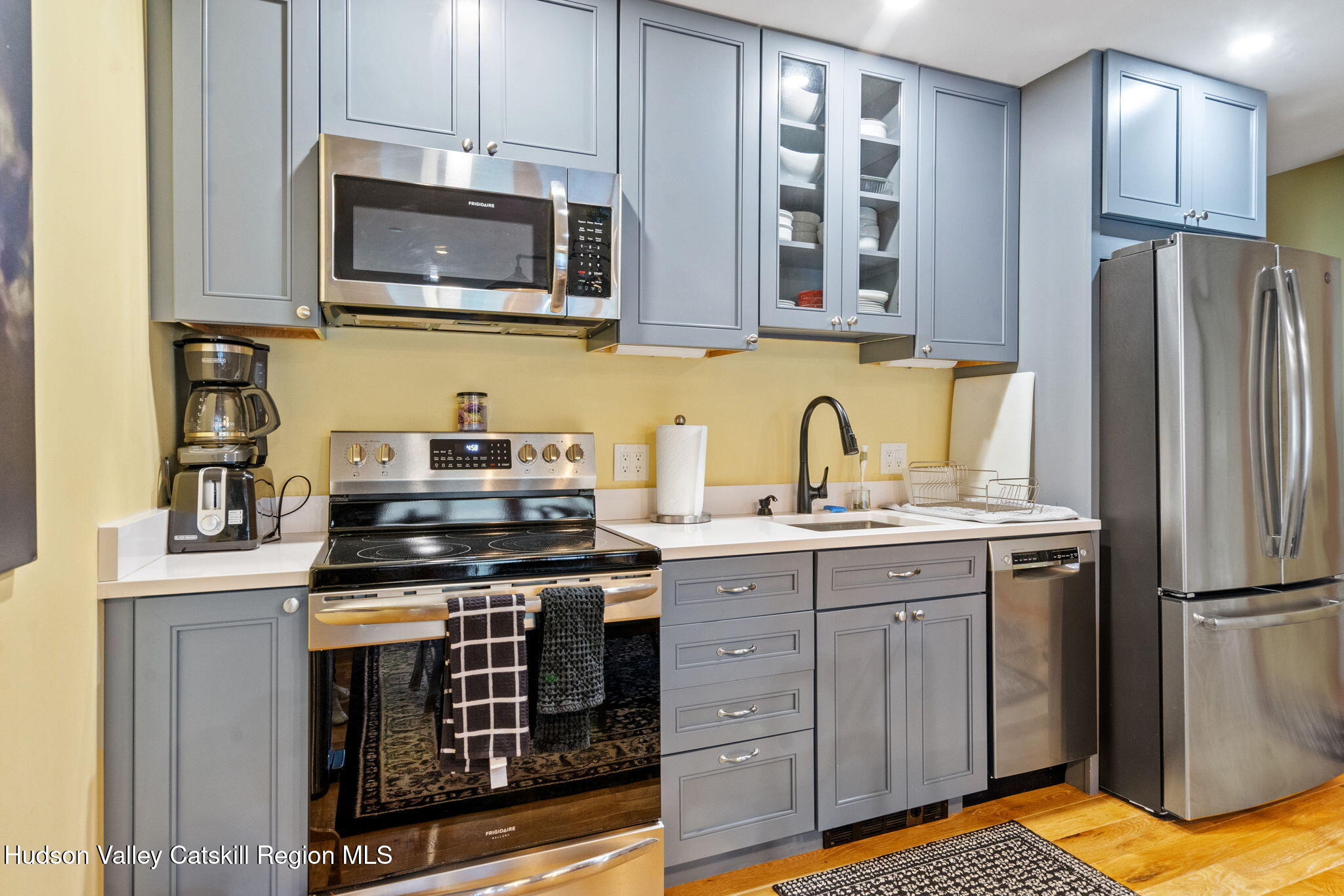 35 Scribner Hollow Road, Unit E3 Hunter, NY 12442 - Photo 17 of 59 a kitchen with stainless steel appliances granite countertop a stove a sink dishwasher and a refrigerator with wooden cabinets