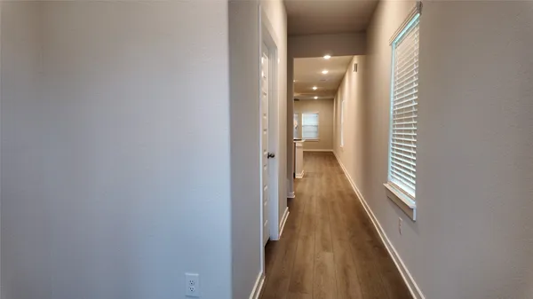 a view of a hallway with wooden floor and staircase