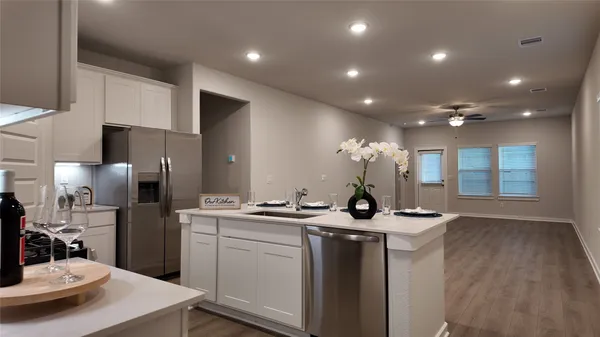 a view of a kitchen with kitchen island a sink stainless steel appliances and cabinets