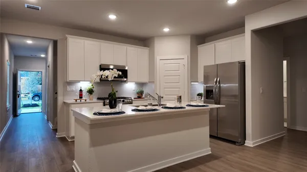 a kitchen with kitchen island a sink stainless steel appliances and wooden floor