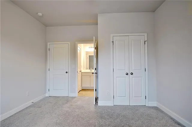 an empty room with a chandelier fan and windows