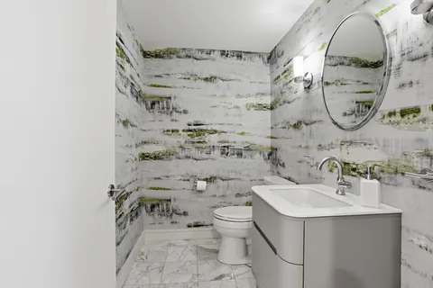 a bathroom with a sink mirror vanity and toilet