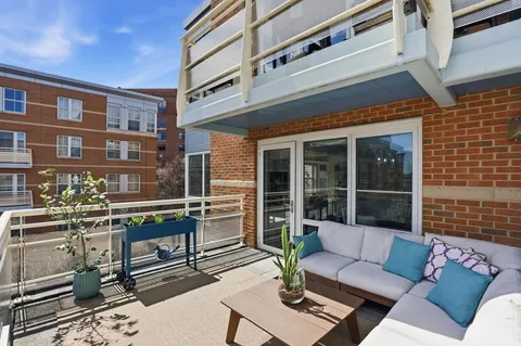 a view of a patio with couches table and chairs with wooden floor