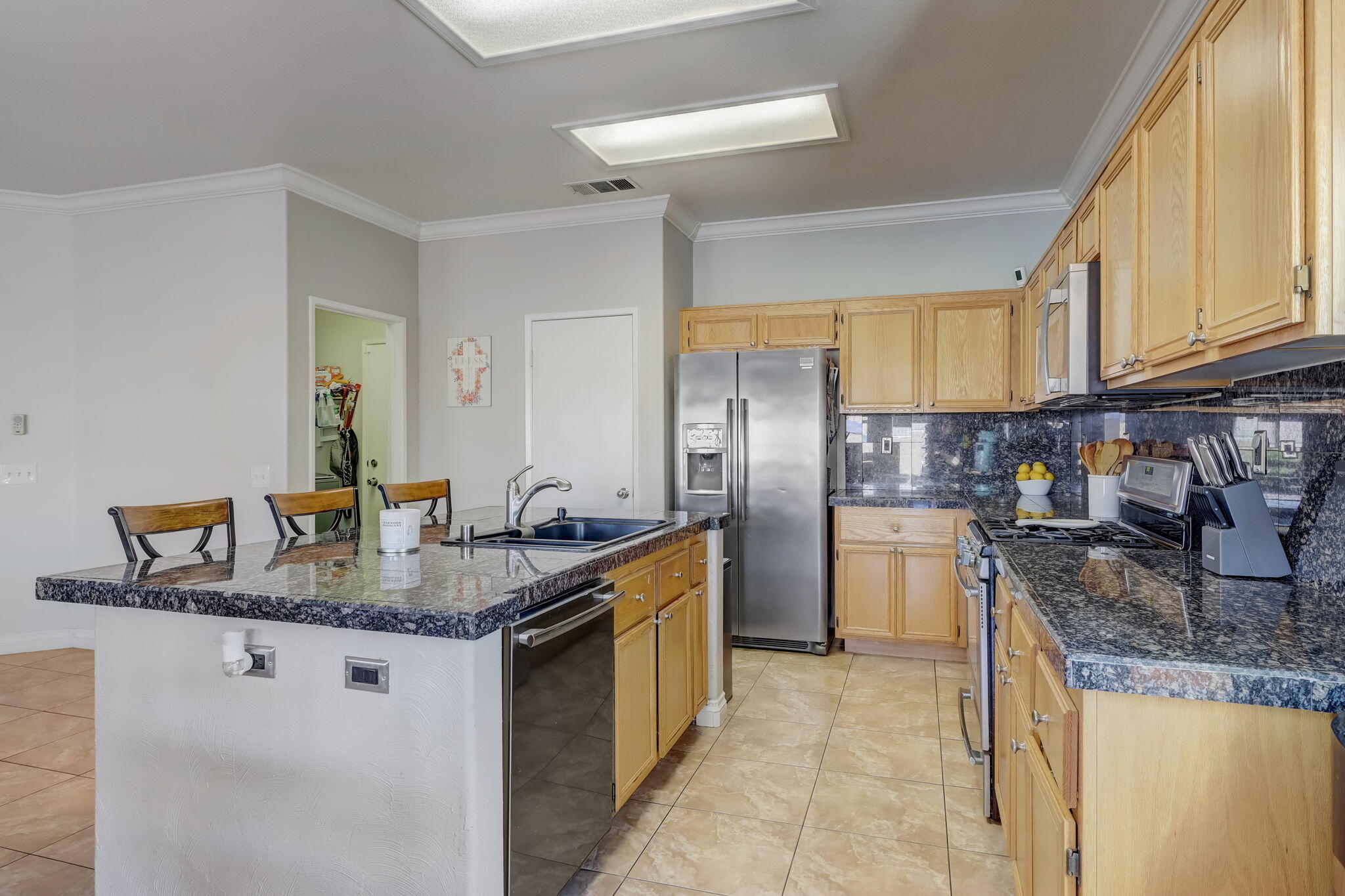 41163 Morris Street Indio, CA 92203 - Photo 17 of 83 a kitchen with stainless steel appliances granite countertop a sink stove and refrigerator