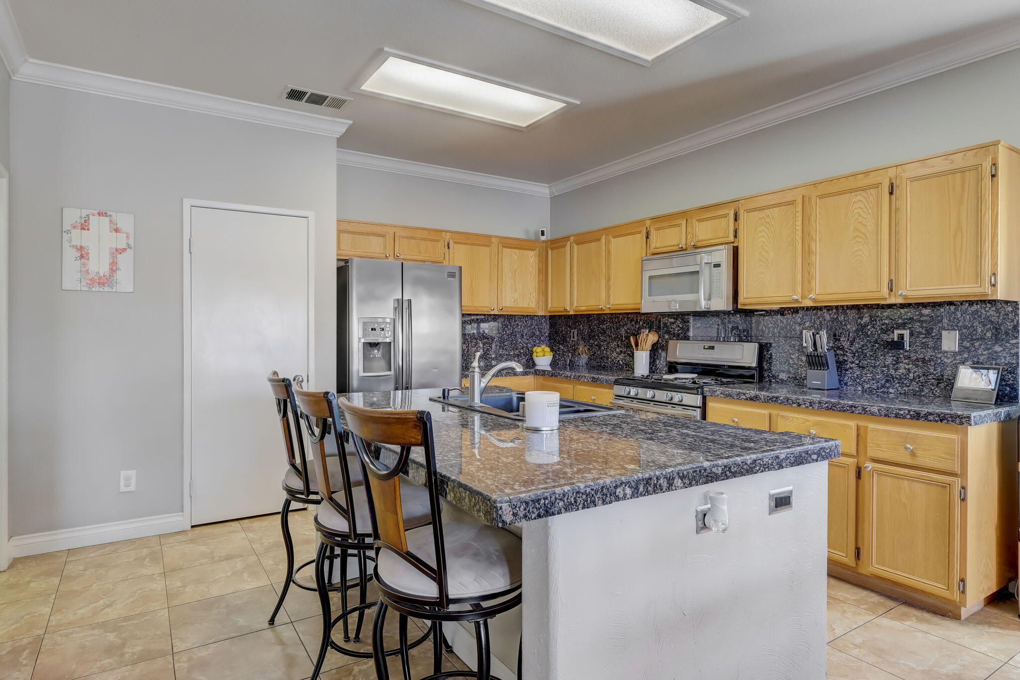 41163 Morris Street Indio, CA 92203 - Photo 24 of 83 a kitchen with stainless steel appliances granite countertop a sink a stove a dining table and chairs
