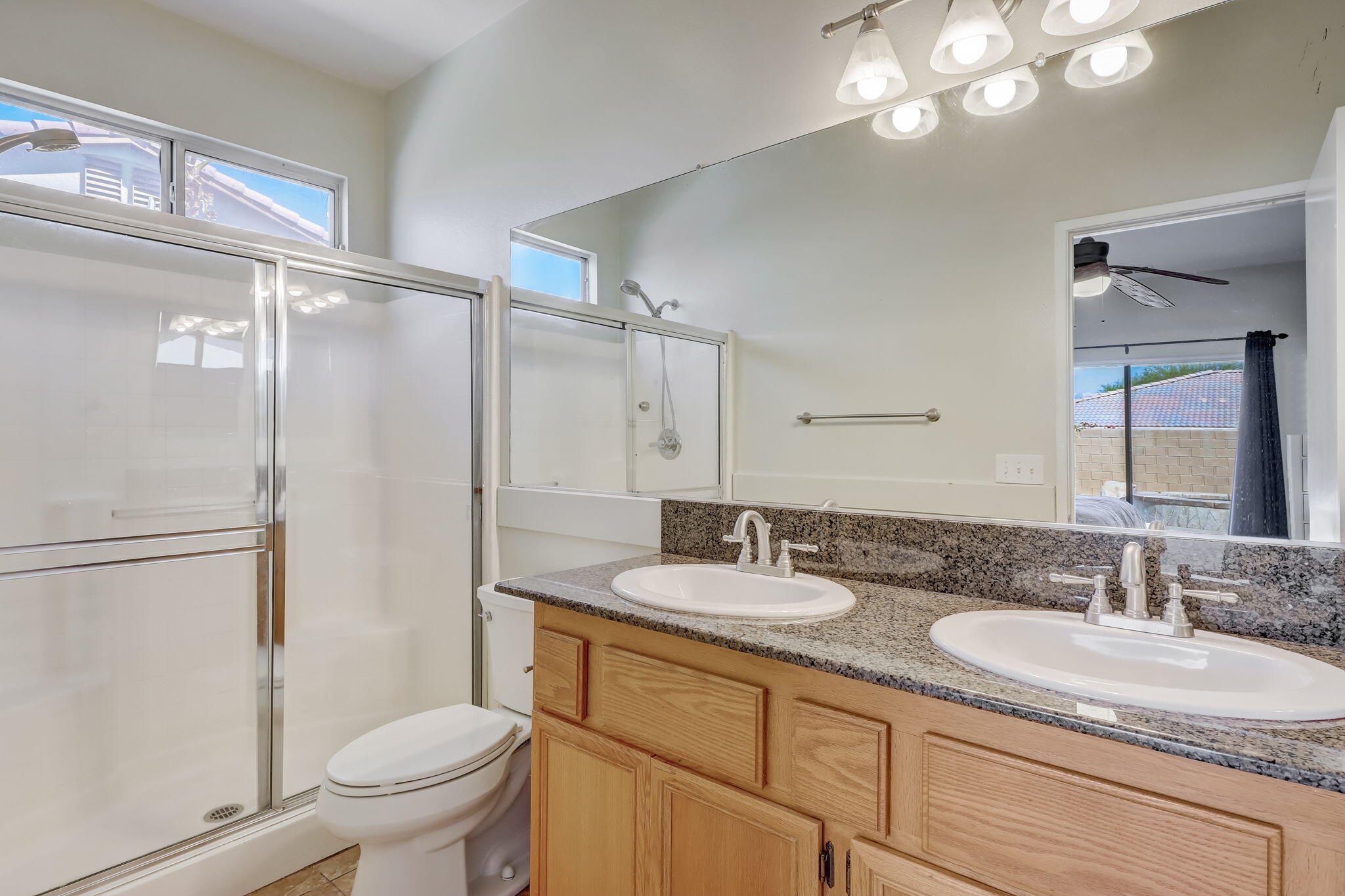 41163 Morris Street Indio, CA 92203 - Photo 40 of 83 a bathroom with a granite countertop sink a toilet a mirror a vanity and shower