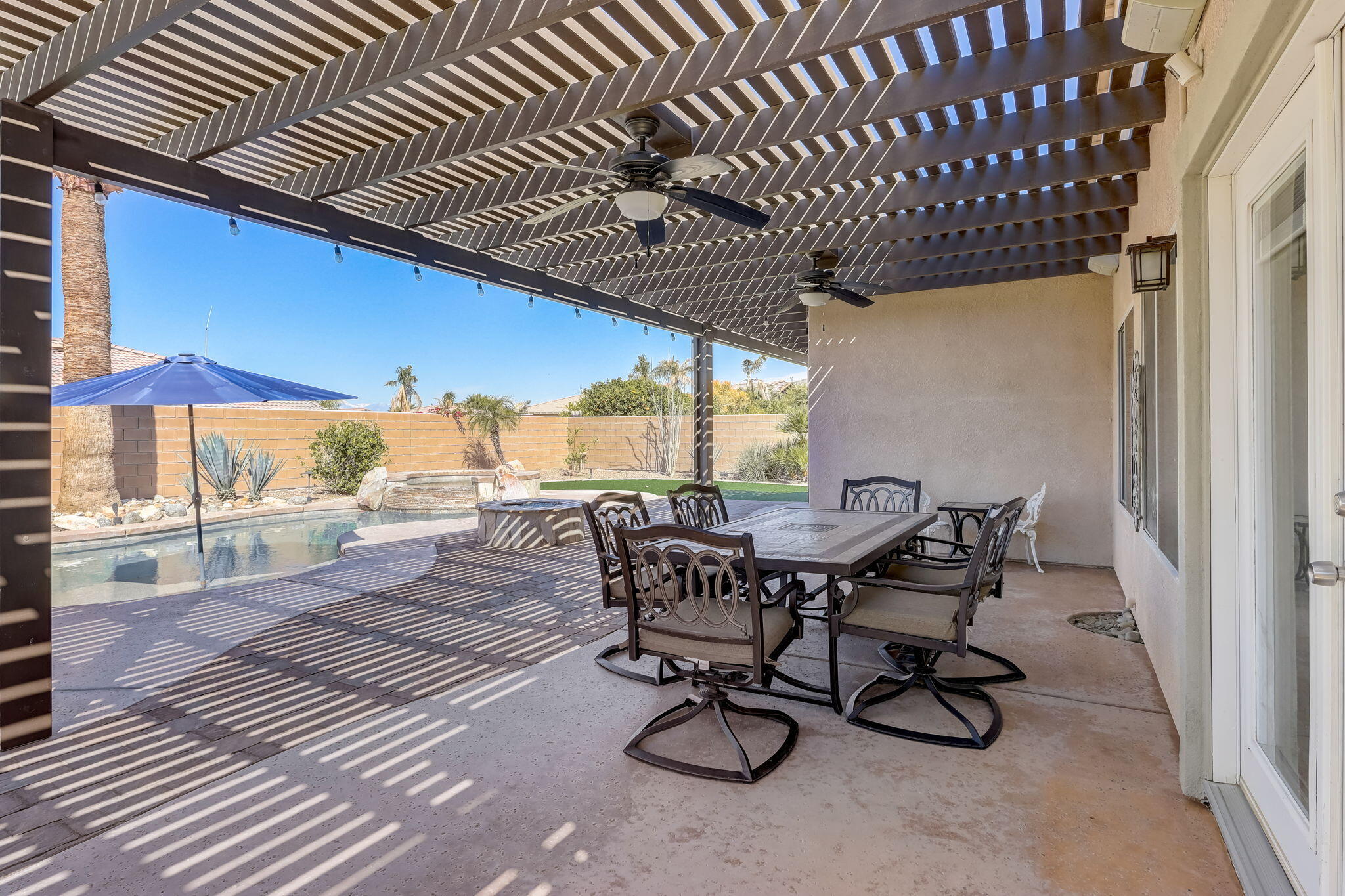 41163 Morris Street Indio, CA 92203 - Photo 44 of 83 a view of a patio with table and chairs with wooden floor and fence