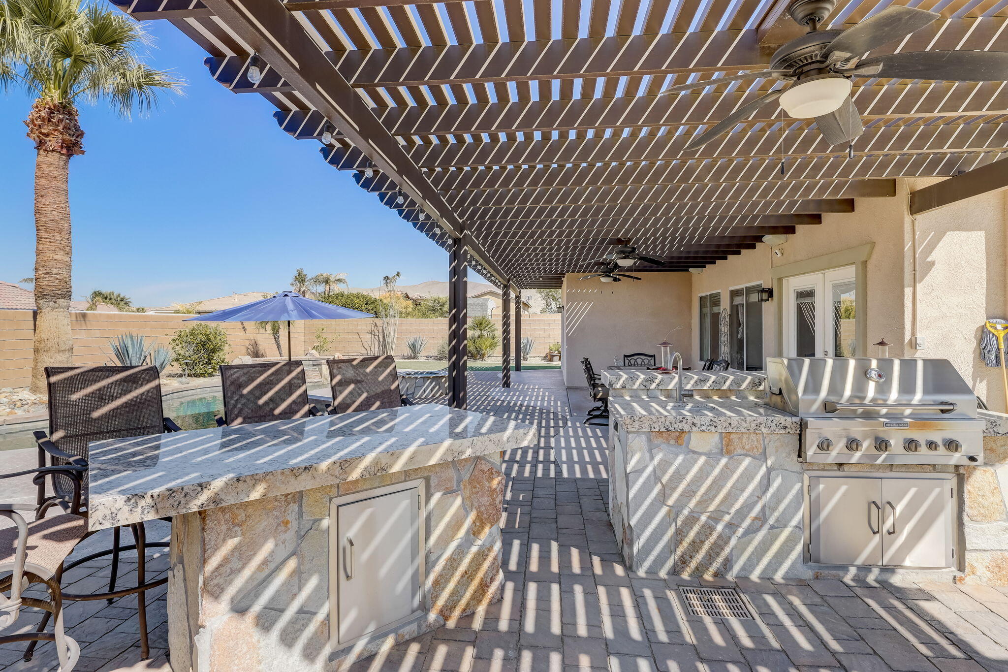 41163 Morris Street Indio, CA 92203 - Photo 53 of 83 a view of a patio with table and chairs with wooden floor and fence