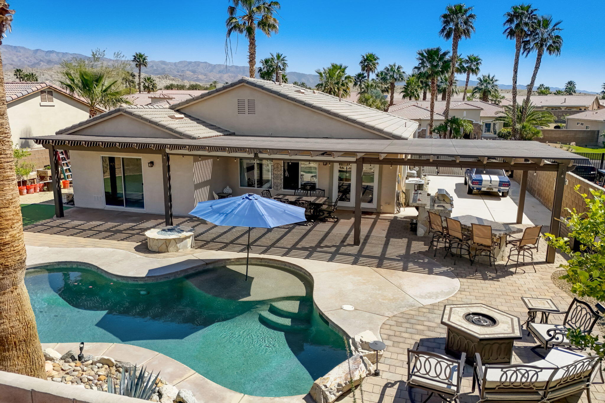 41163 Morris Street Indio, CA 92203 - Photo 66 of 83 a view of a patio with table and chairs potted plants and palm tree