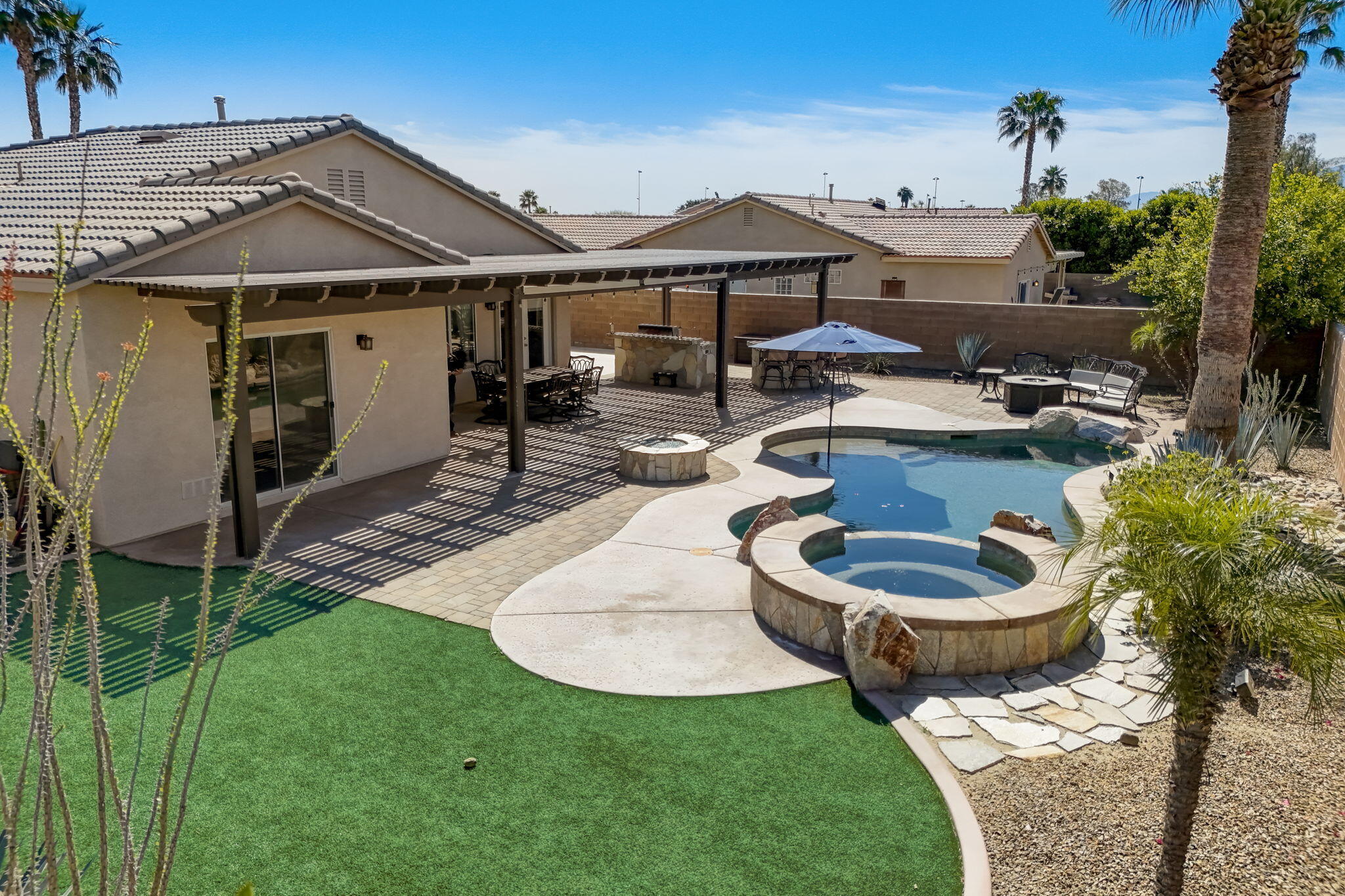 41163 Morris Street Indio, CA 92203 - Photo 67 of 83 a view of a house with backyard sitting area and swimming pool