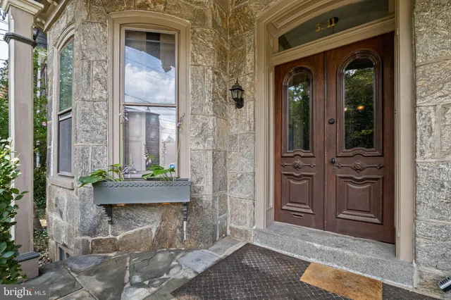 a front view of a house with a potted plant and floor to ceiling windows