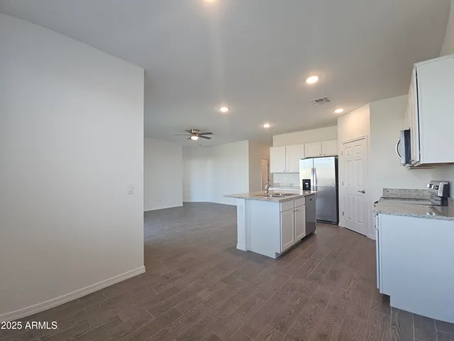 a view of a kitchen with refrigerator and a sink