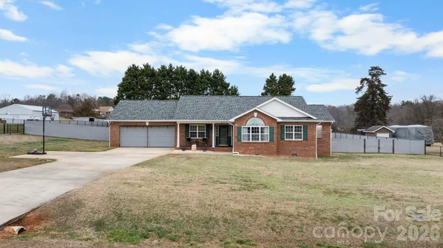 a front view of a house with a garden and trees