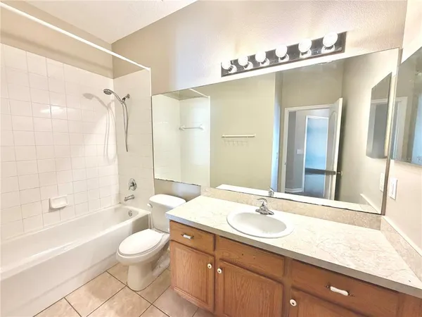 a bathroom with a granite countertop sink a toilet a mirror and shower