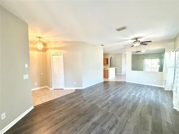 a view of a big room with wooden floor and windows