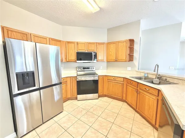 a kitchen with stainless steel appliances a refrigerator sink and microwave