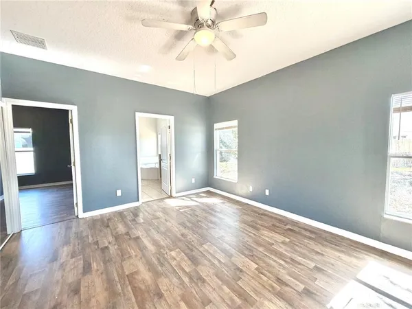 a view of a livingroom with a chandelier fan and windows