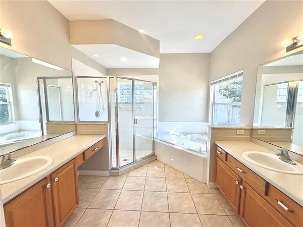 a large bathroom with a granite countertop tub a sink a mirror and a shower