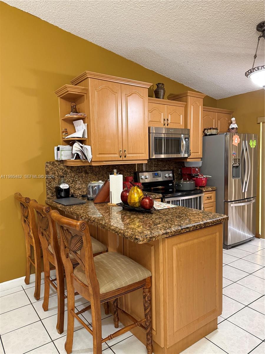 a kitchen with stainless steel appliances granite countertop a stove and a refrigerator